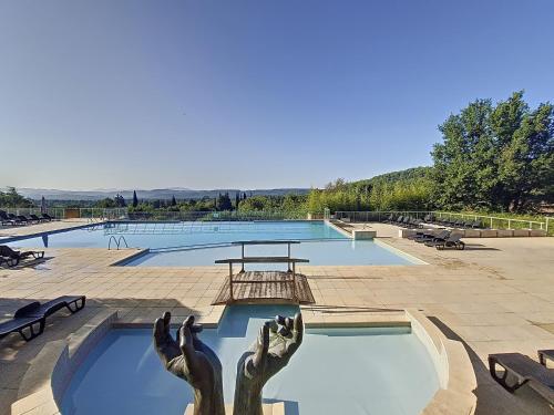 une piscine avec une statue de main s'arrêtant dans l'eau dans l'établissement Callian : Appartement sécurisé près du Lac, animaux admis - FR-1-779-12, à Callian