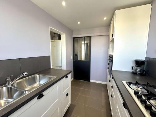 une cuisine avec un évier et une cuisinière dans l'établissement Appartement climatisé à Fréjus, parking privé - FR-1-226A-208, à Fréjus