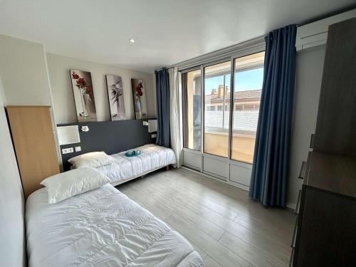 une chambre avec deux lits et une grande fenêtre dans l'établissement Appartement climatisé à Fréjus, parking privé - FR-1-226A-208, à Fréjus