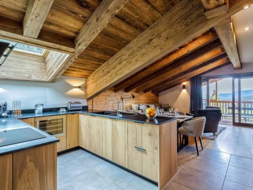 une cuisine avec des placards en bois et une grande fenêtre dans l'établissement Appartement moderne avec jacuzzi et sauna - Les Saisies - FR-1-810-32, à Hauteluce