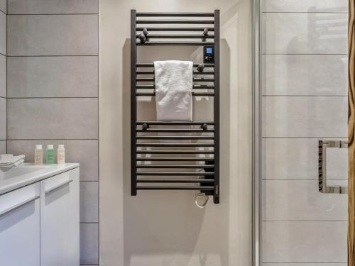La salle de bains est pourvue d'un porte-serviettes sur le mur. dans l'établissement Appartement moderne avec jacuzzi et sauna - Les Saisies - FR-1-810-32, à Hauteluce