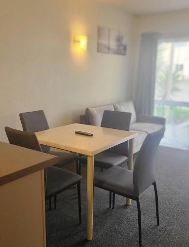 a room with a table and chairs and a couch at BK's Fountain Court Motel in Napier