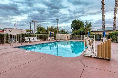 a swimming pool with chairs and a fence at Motel 6-Nogales, AZ - Mariposa Road in Nogales