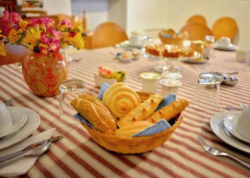 a table with a basket of bread and a vase with flowers at Pessighette Dimora Di Campagna in Bosa