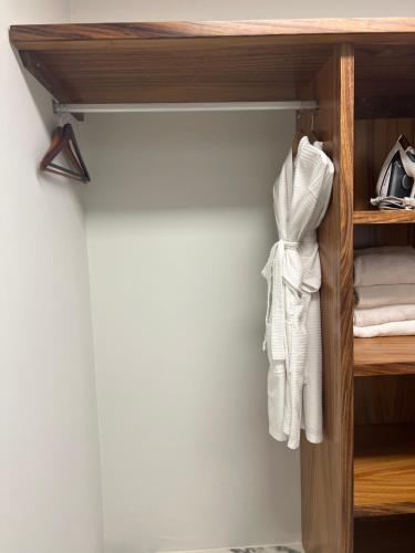 a closet with white towels on a wooden shelf at P V near Colomitos Beach Boutique Hotel in Puerto Vallarta