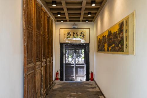 a hallway with a door in a building at Elsewhere Hotel Inn North Street Branch in Pingyao