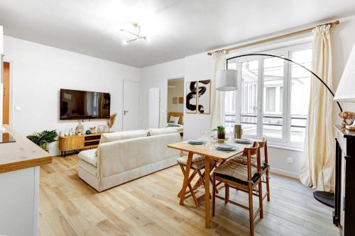 un salon avec une table et un canapé dans l'établissement Appartement de Prestige au Marais pour 6 Voyageurs, à Paris