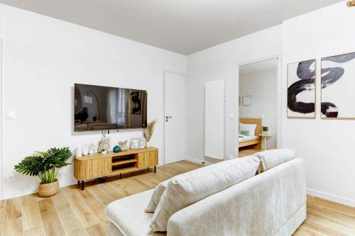 un salon avec un canapé et une télévision dans l'établissement Appartement de Prestige au Marais pour 6 Voyageurs, à Paris