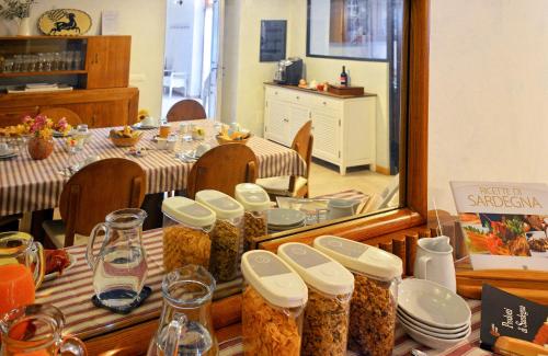 a table with many jars of food on it at Pessighette Dimora Di Campagna in Bosa