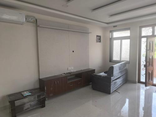 a living room with a chair and a large mirror at Orraica Stays Aurum Vajra in Haidar Sāhibgūda