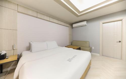 a bedroom with a large white bed and a skylight at Eco Hotel in Mokpo