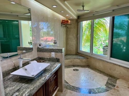 a bathroom with a sink and a large mirror at P V near Colomitos Beach Boutique Hotel in Puerto Vallarta