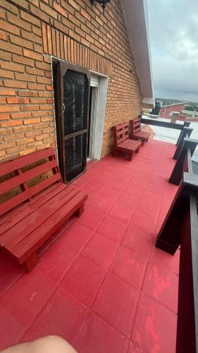 two benches sitting on a patio with a brick building at CAMIGIGA Alquiler en Barra de Chuy, Uruguay in Barra del Chuy