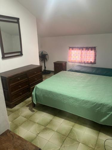 a bedroom with a bed and a dresser and a window at CAMIGIGA Alquiler en Barra de Chuy, Uruguay in Barra del Chuy