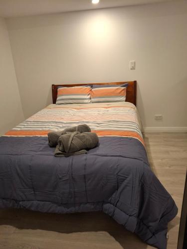 a bed with a stuffed animal on top of it at Holly's Flat Close to Ferry And EV in Wellington