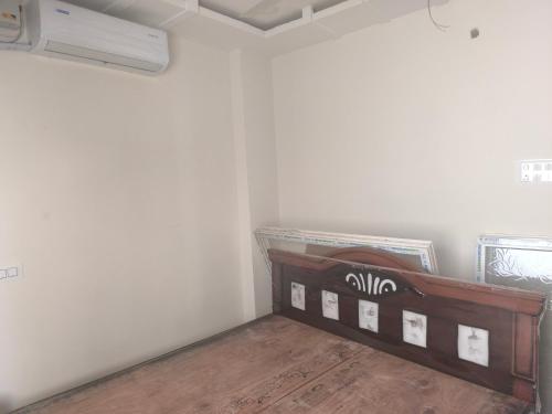 a bed in a room with white walls and wooden floors at Orraica Stays Aurum Vajra in Haidar Sāhibgūda