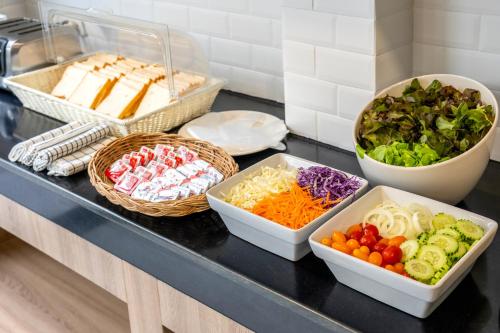 einer Theke mit Schalen aus Gemüse und anderen Lebensmitteln in der Unterkunft HATCHAO HERITAGE BEACH FRONT RESORT in Ban Hat Cha Samran