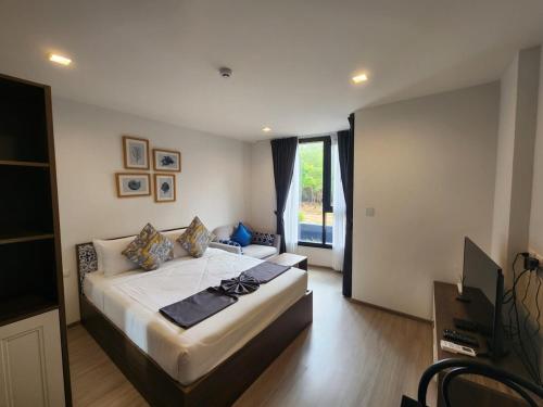 a bedroom with a large bed and a large window at The Base Central Phuket-B20W in Ban Rangeng