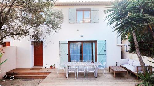 un patio avec une table et des chaises devant une maison dans l'établissement Villa moderne jardin parking centre Hyères, à Hyères