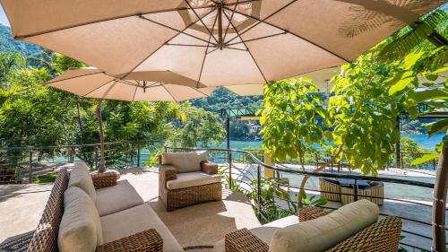 a patio with chairs and umbrellas on a balcony at P V near Colomitos Beach Boutique Hotel in Puerto Vallarta