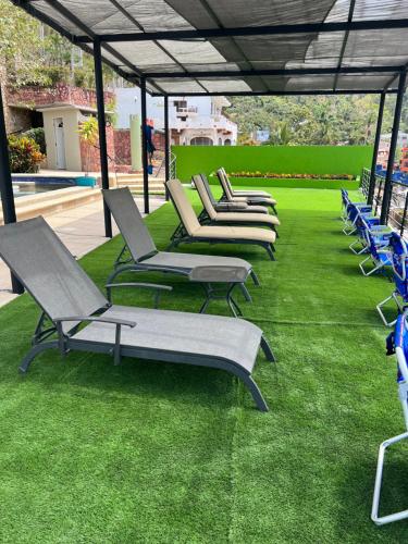 a row of chaise lounges sitting on the grass at P V near Colomitos Beach Boutique Hotel in Puerto Vallarta