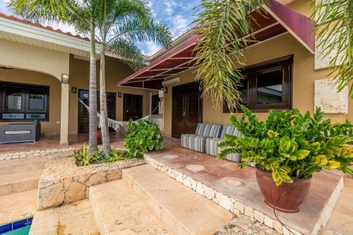 a house with palm trees and a swimming pool at 3BR Villa Serene Grace with Private Pool by Bocobay in Oranjestad