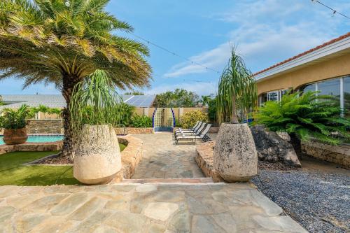 a backyard with a palm tree and a swimming pool at 3BR Villa Serene Grace with Private Pool by Bocobay in Oranjestad