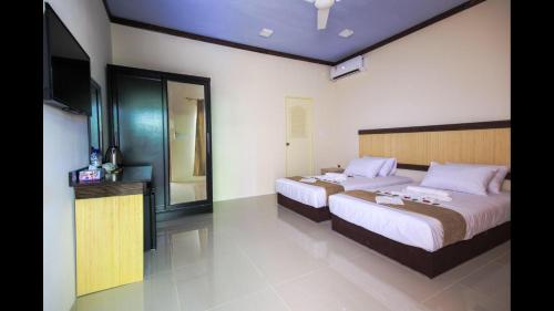 a bedroom with two beds and a flat screen tv at Ari Stay Thoddoo in Thoddoo