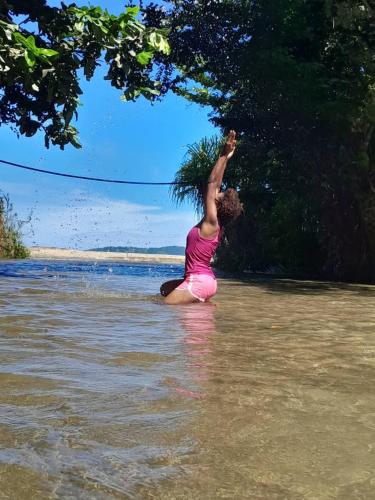 a woman standing in the water on a beach at J60 Beach Guest House in Asini