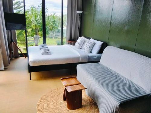 una habitación de hotel con dos camas y un sofá en Nara Black Mountain, en Ban Tha Chang