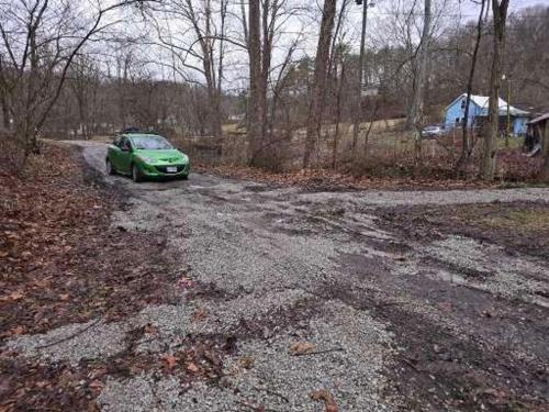 a green car parked on the side of a road at The Happy Place in Glouster