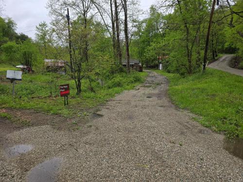 a dirt road with a sign on the side of it at The Happy Place in Glouster