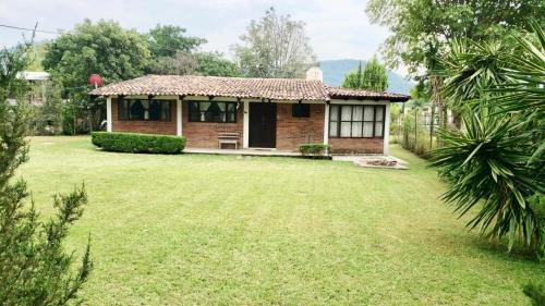 una pequeña casa con un patio delante en Cabaña cerca del Santuario Valle de Bravo, en Valle de Bravo