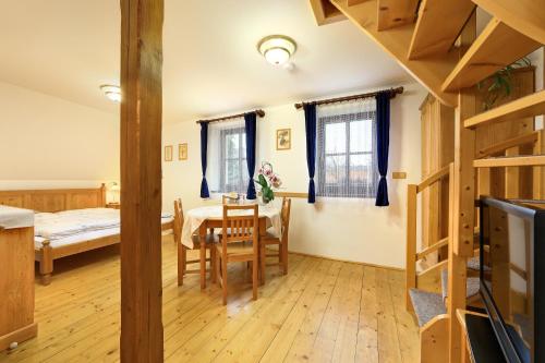 a room with a table and chairs and a bedroom at Penzion Tilia in Český Krumlov