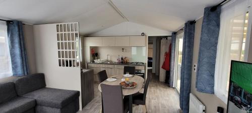 Il comprend un salon et une cuisine avec une table et un canapé. dans l'établissement mobil home, à Pont-Aven
