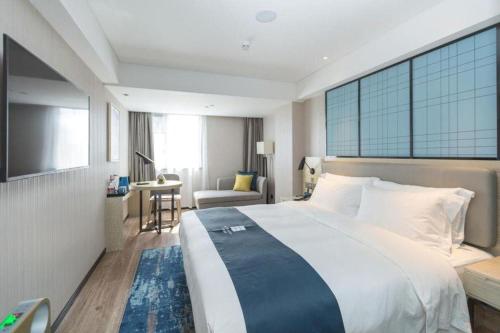 a hotel room with a large bed and a desk at Echarm Hotel Shenzhen World Exhibition and Convention Center in Shenzhen