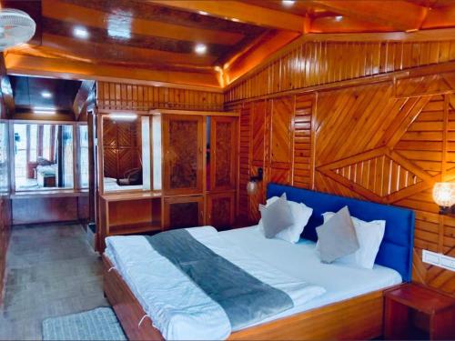 a bedroom with a large bed in a wooden room at Nainital Stays in Nainital