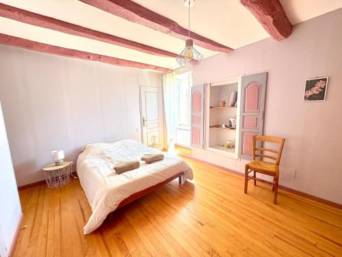 une chambre avec un lit et une chaise dedans dans l'établissement Maison de charme & pierre du Lot, à Blars