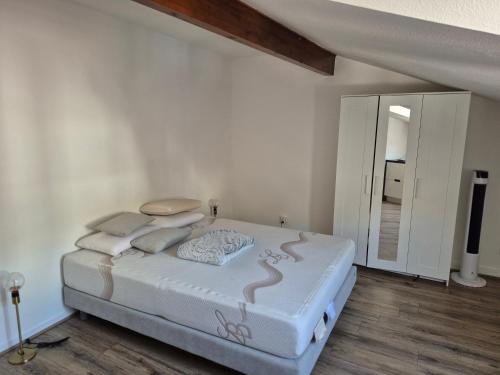 une chambre blanche avec un lit et un miroir dans l'établissement T2 Centre proche gare, à Voiron