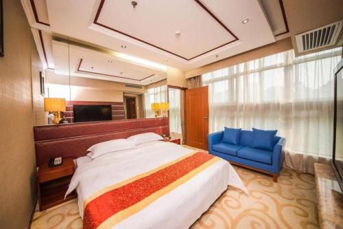 a bedroom with a large bed and a blue chair at Milu Hotel in Guangzhou
