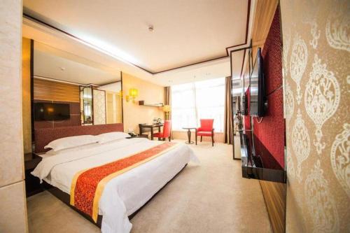 a hotel room with a large bed and a television at Milu Hotel in Guangzhou