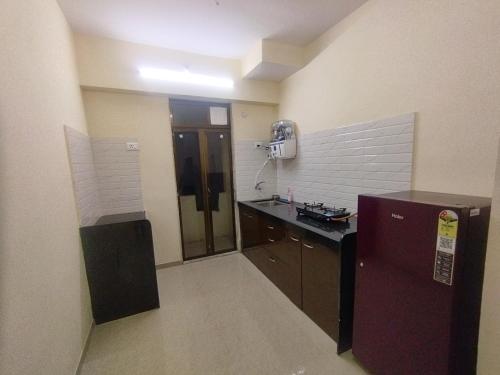 a room with a kitchen with a sink and a refrigerator at Private Room At Pushpanjali Residency Phase 3 S1 Block Ovale Ghodbunder Road Thane West in Thane