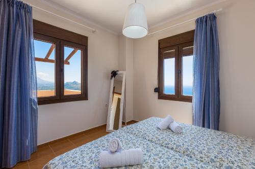 a bedroom with a bed and two windows at Anastasia Villa, view to Libyan sea, By ThinkVilla in Sellía