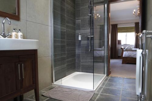 a bathroom with a glass shower and a sink at The Lamb Inn in Chinley