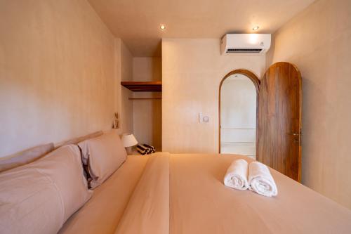 a bedroom with a bed with two towels on it at Mayiki Boutique Hotel in Uluwatu
