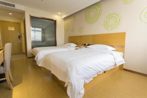 Una cama o camas en una habitación de GreenTree Inn Zhangjiagang Yangshe Old Street Stadium