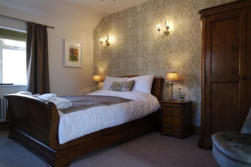 um quarto com uma cama grande e 2 candeeiros em The Lamb Inn em Chinley