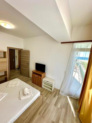 a bedroom with a bed and a tv and a window at Summerland Seaview Apartments in Mamaia