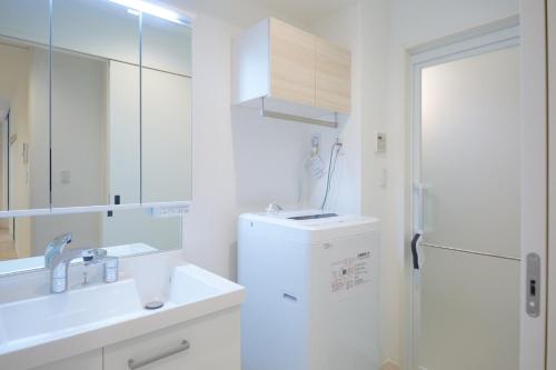 a white bathroom with a sink and a refrigerator at Z LAND Enoshima in Fujisawa