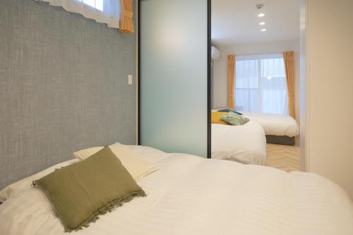 a bedroom with a white bed and a mirror at Z LAND Enoshima in Fujisawa